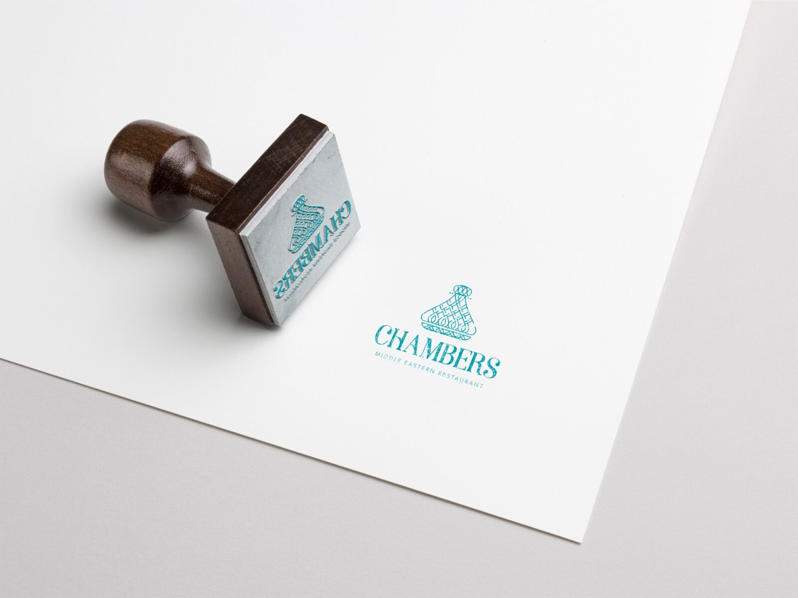 A rubber stamp printing the Chambers logo in teal