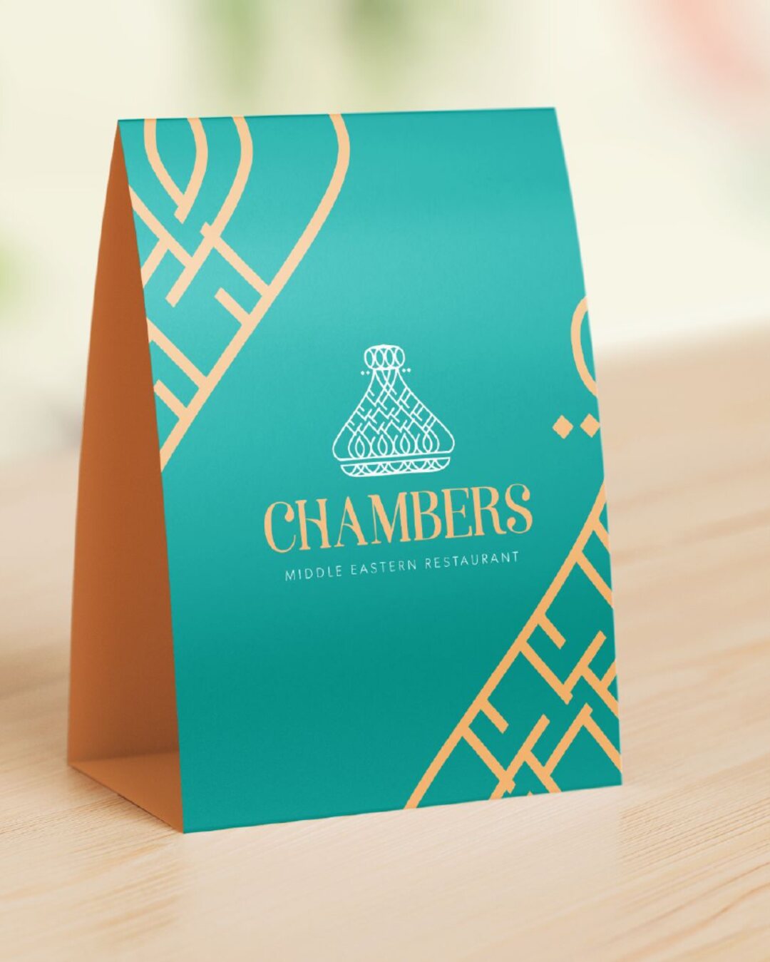 A Turquoise table tent with the Chambers logo and Saffron lattice