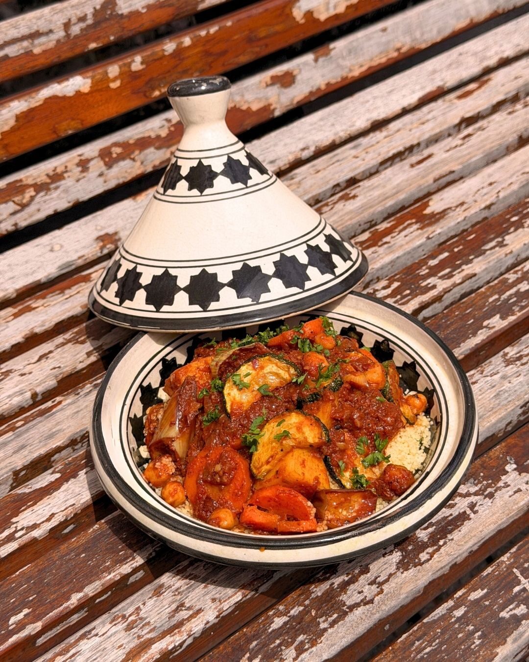 A painted ceramic tagine on a wooden table at Chambers