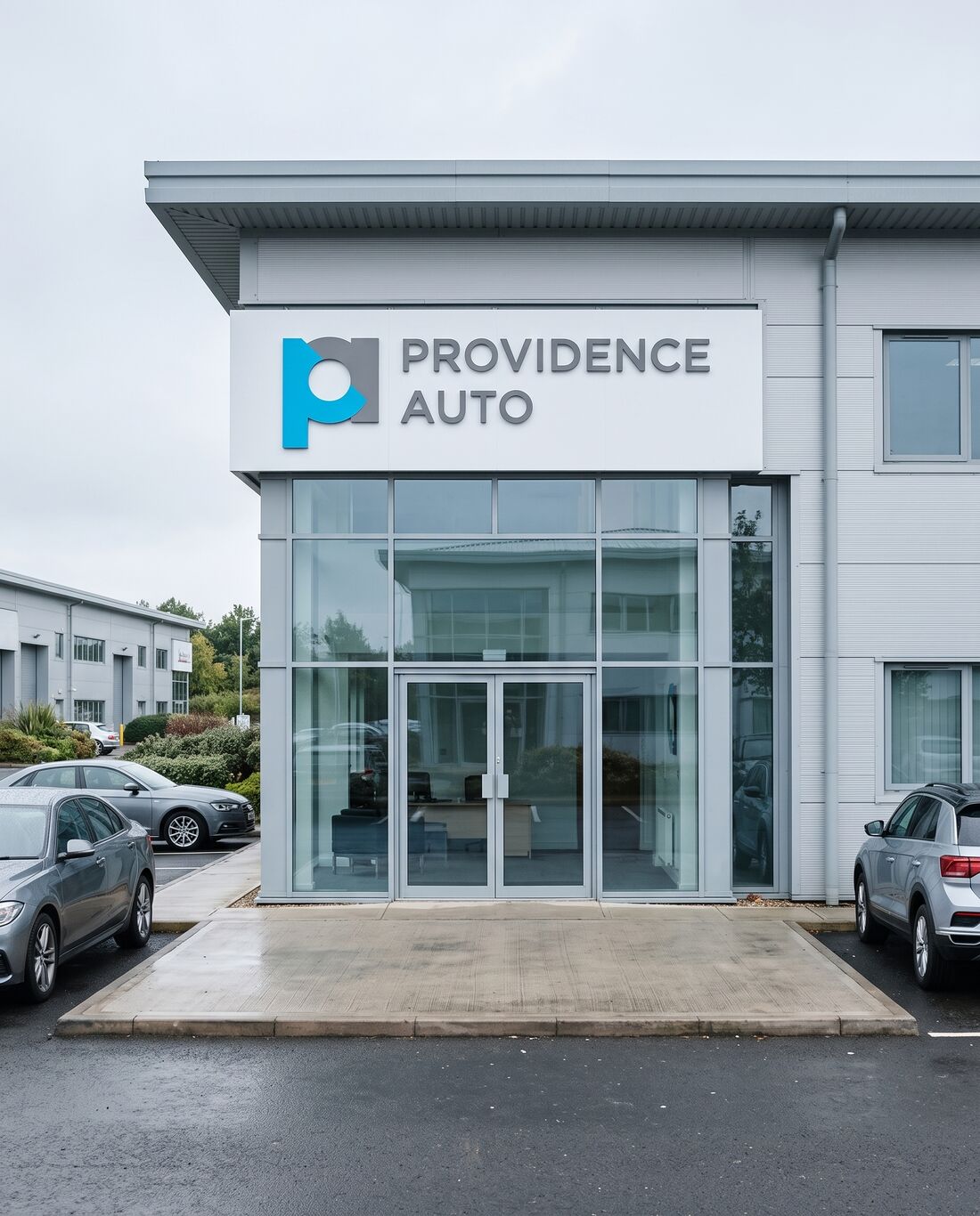 A modern office on an industrial estate, the Providence Auto logo on the fascia above the glass entrance
